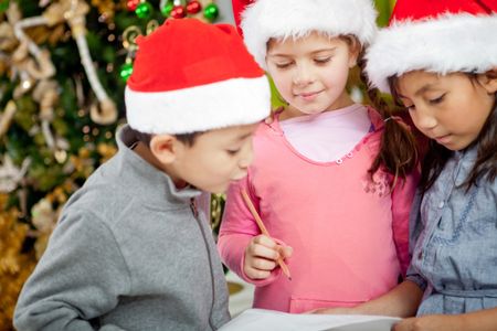 Children writing Christmas wish list for Santa