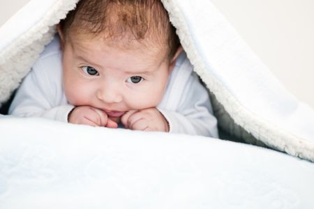 Portrait of a gorgeous cute baby under the blankets