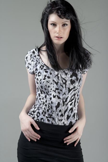 Young woman in a black skirt and animal print top