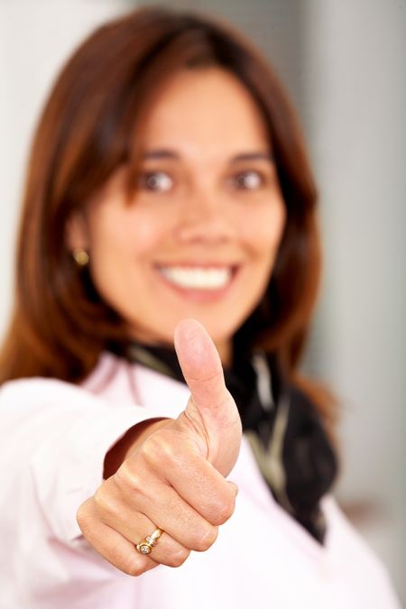 business woman smiling doing the thumbs up sign in an office