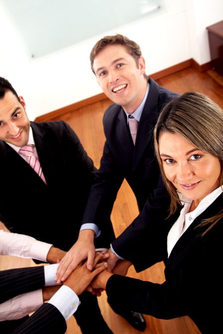 business teamwork - all young and successful businessmen and businesswomen at the office with hands together