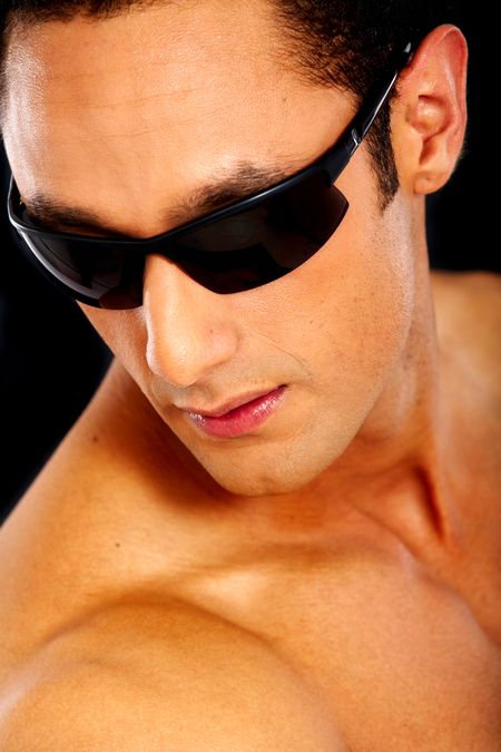 fashion man portrait wearing sunglasses isolated over a black background