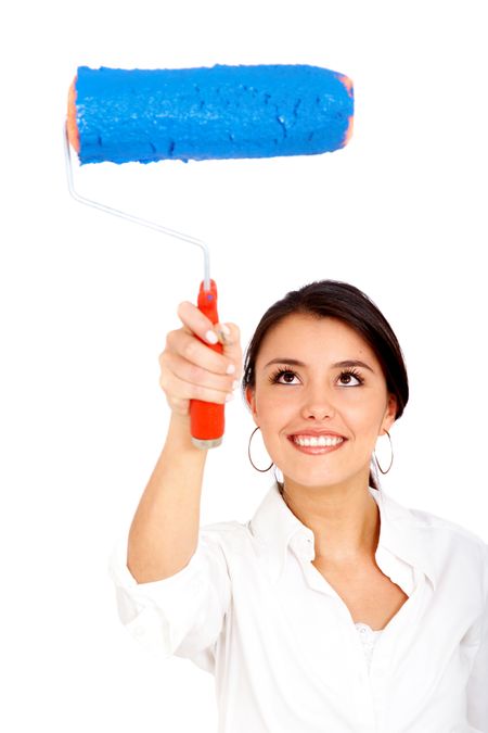 woman painting a wall in front of her with blue paint and a roller