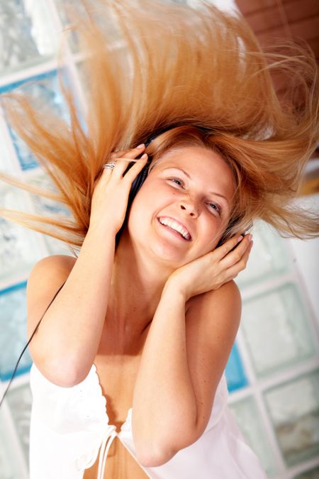 blonde woman listening to music looking happy at home