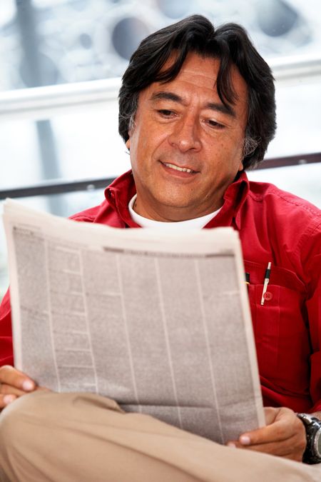 senior man reading a newspaper at home
