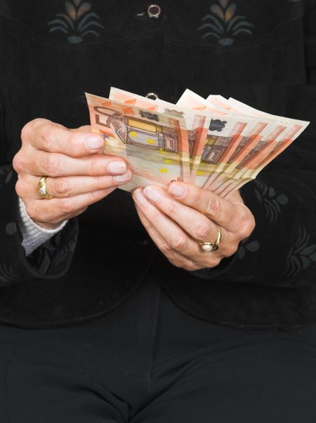 hands holding some euros over black