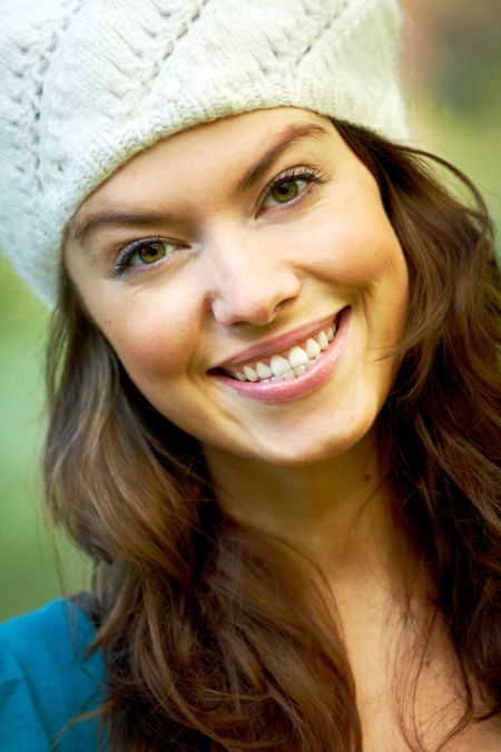 fashion woman smiling outdoors and wearing a hat