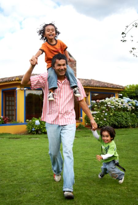 family lifestyle portrait of a dad with their two kids having fun outdoors