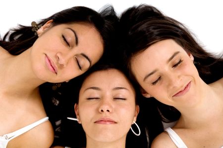 group of friends sleeping with their heads together on the floor - isolated over a white background