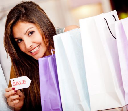 Woman shopping on sale looking happy with her purchases