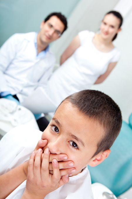 Scared boy at the dentist refusing treatment