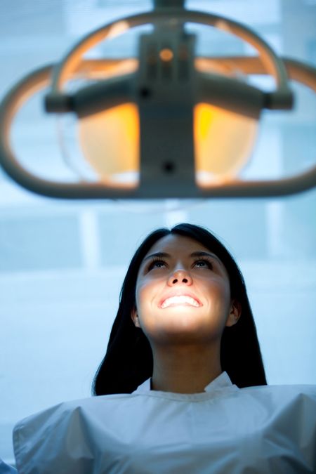 Girl at the dentist sitting on a chair under the light