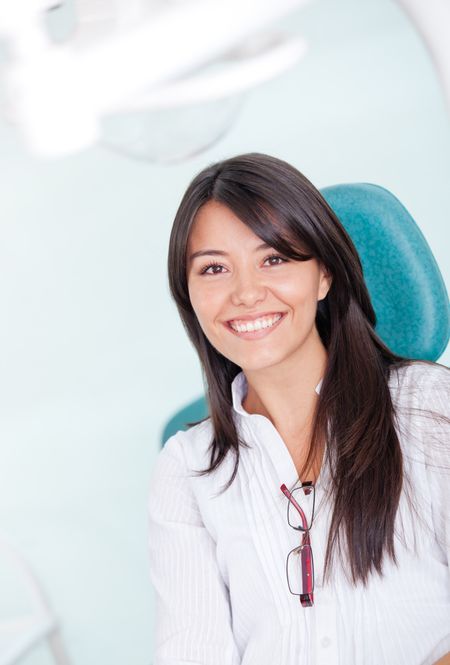 Smiley young woman visiting the dentist and looking happy