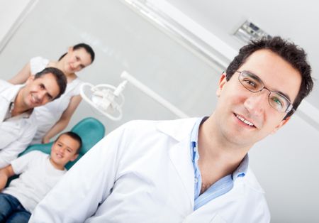 Male dentist smiling with his team at his practice