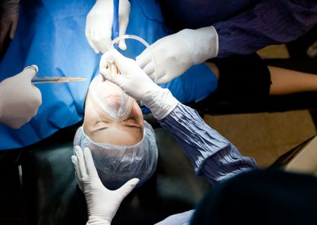 Woman in surgery breathing through an oxygen mask