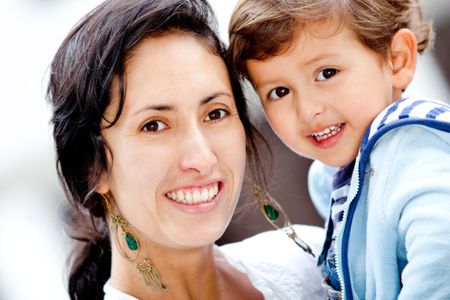 Portrait of a young mother holding her son outdoors