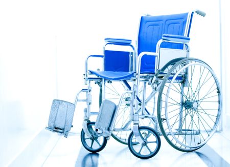 Wheelchair at the entrance of a hospital over a white background