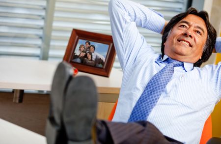 Business man relaxing at the office with feet on desk