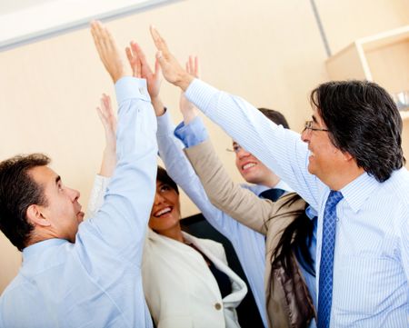 Successful business group giving a high-five at the office