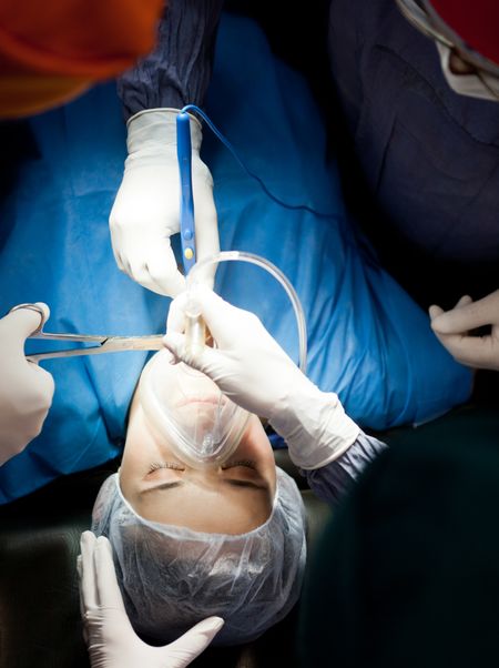 Patient in surgery breathing through an oxygen mask