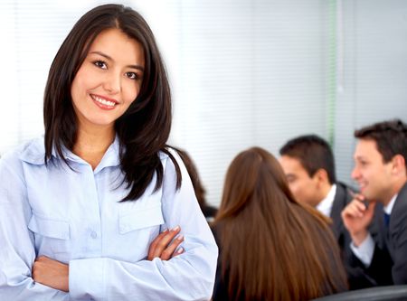 business woman smiling leading a team during an office meeting