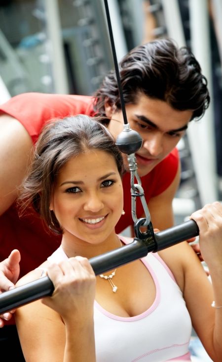 gym woman and her trainer doing weights exercises