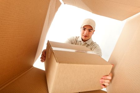 Delivery man holding a package inside a cardboard box