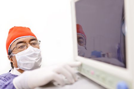 Doctor checking vital signs in a monitor at the surgery room