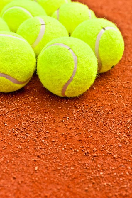 Close-up of tennis balls on a clay court