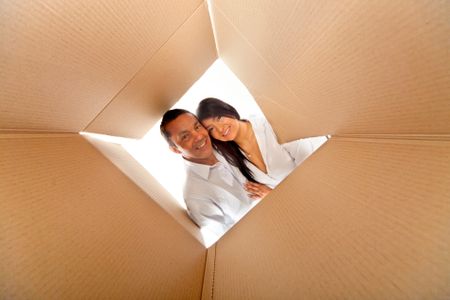 Couple in a cardboard box ready to move house