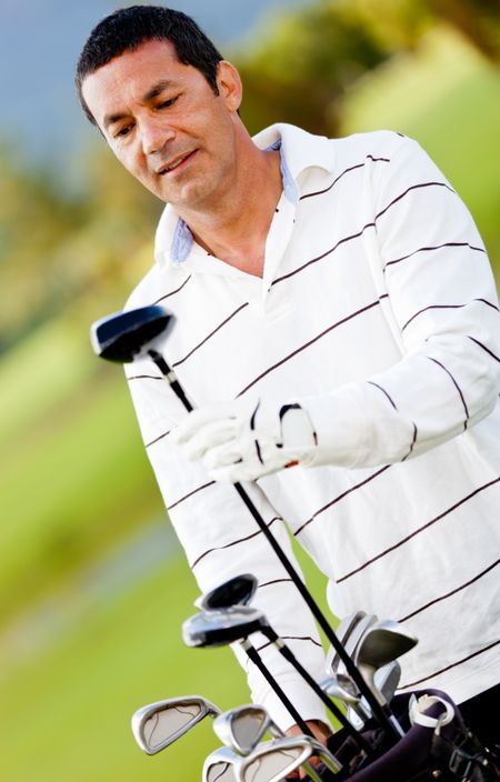Man playing golf and choosing a golf-club from the bag