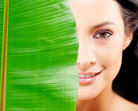 Woman portrait with a leave covering her face - natural beauty concepts