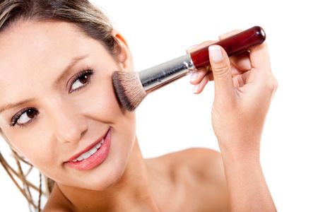 Woman applying rouge with a make up brush - isolated over a white background
