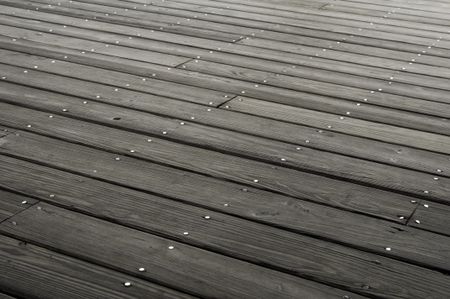 Rows of nailheads in planks of boardwalk platform