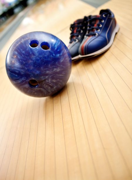 Bowling kit with shoes and ball on the alley