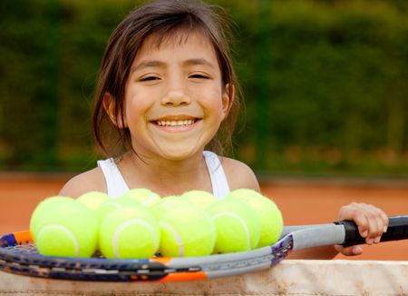 Young female player holding tennis balls with her racket
