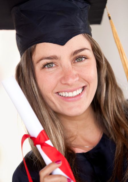 Beautiful female graduate holding her diploma and smiling