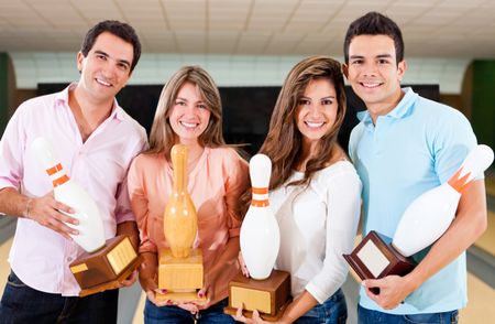 Happy group of friends winning a bowling trophy