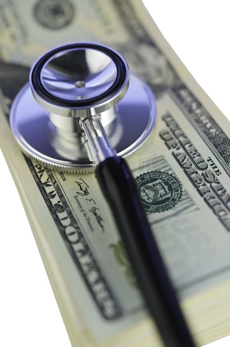 Financial checkup: Stethoscope on pile of U.S. twenty-dollar bills isolated on white background