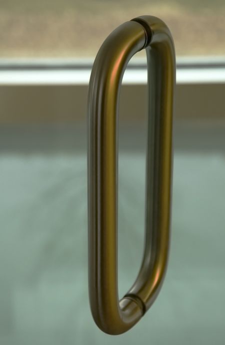 Doorhandle and its reflection on glass office door, with retention pond in background