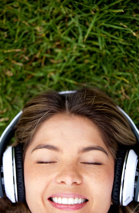 Woman lying on the grass with headphones