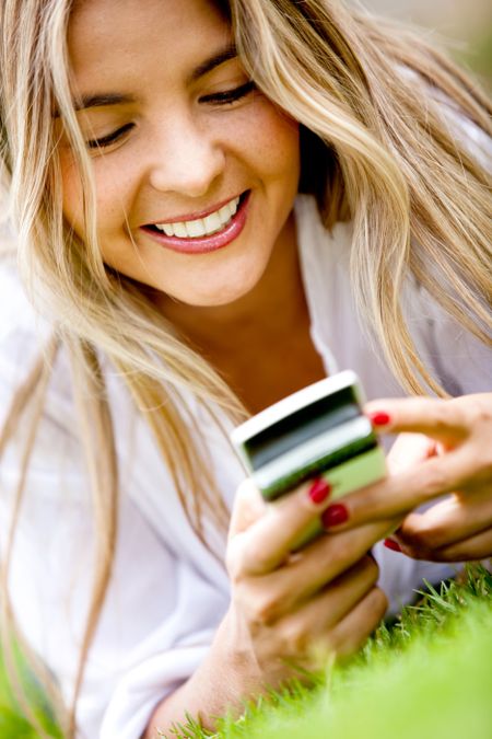 Happy woman texting on her cell phone outdoors
