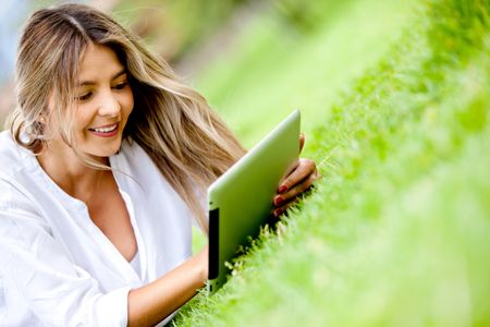 Woman using a tablet computer outdoors - technology concepts