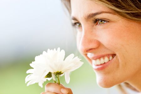 Beautiful woman portrait smelling a flower and smiling