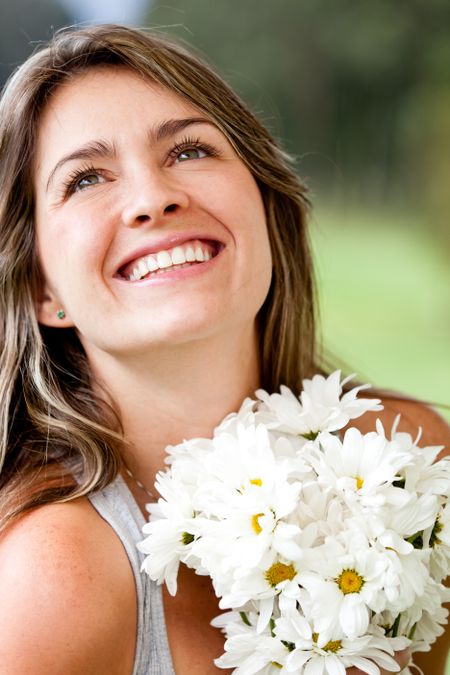 Happy woman smiling with a bunch of flowers