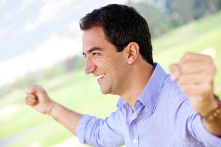 Excited man celebrating his victory with arms up
