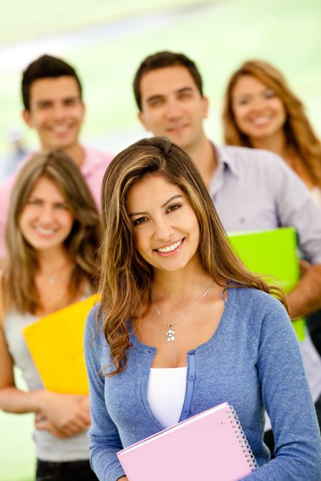Group of college students holding notebooks and smiling