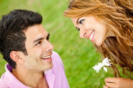 Romantic couple with a man giving a flower to his girlfriend