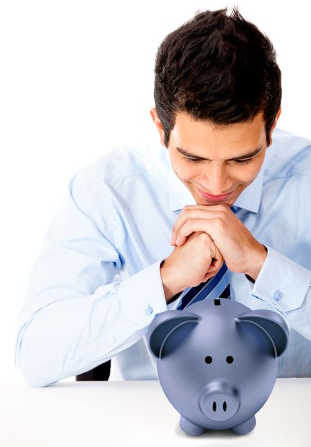 Businessman staring at a piggybank - isolated over a white background