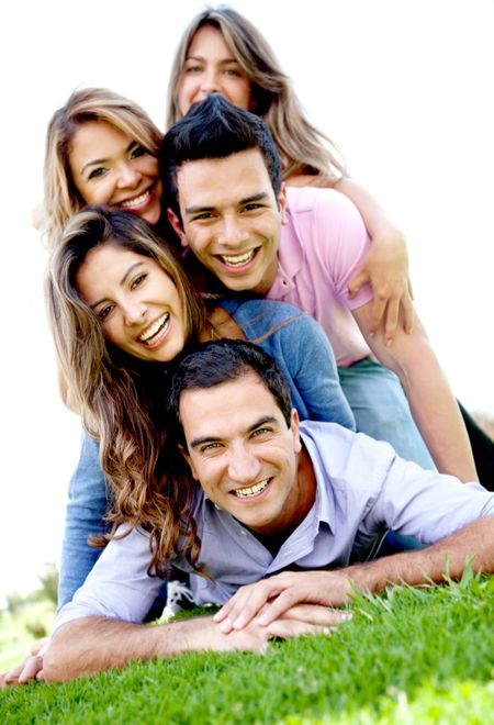 Group of friends lying outdoors on top of each other having fun